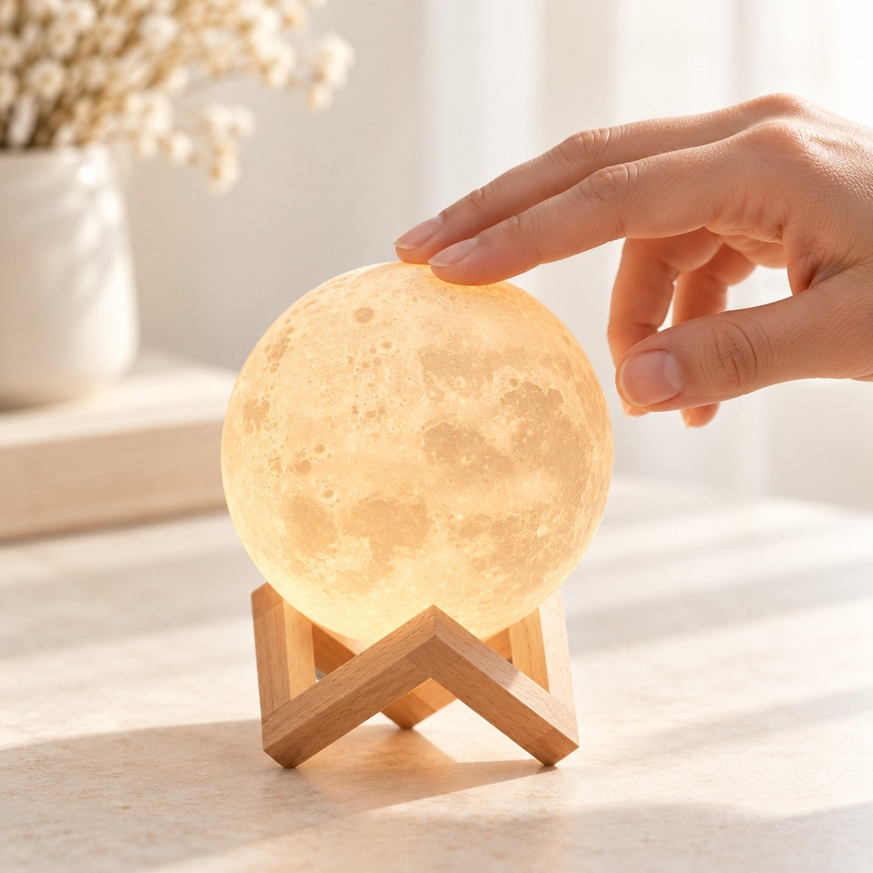 Une main touche la Petite Lune pour l’allumer, en plein jour