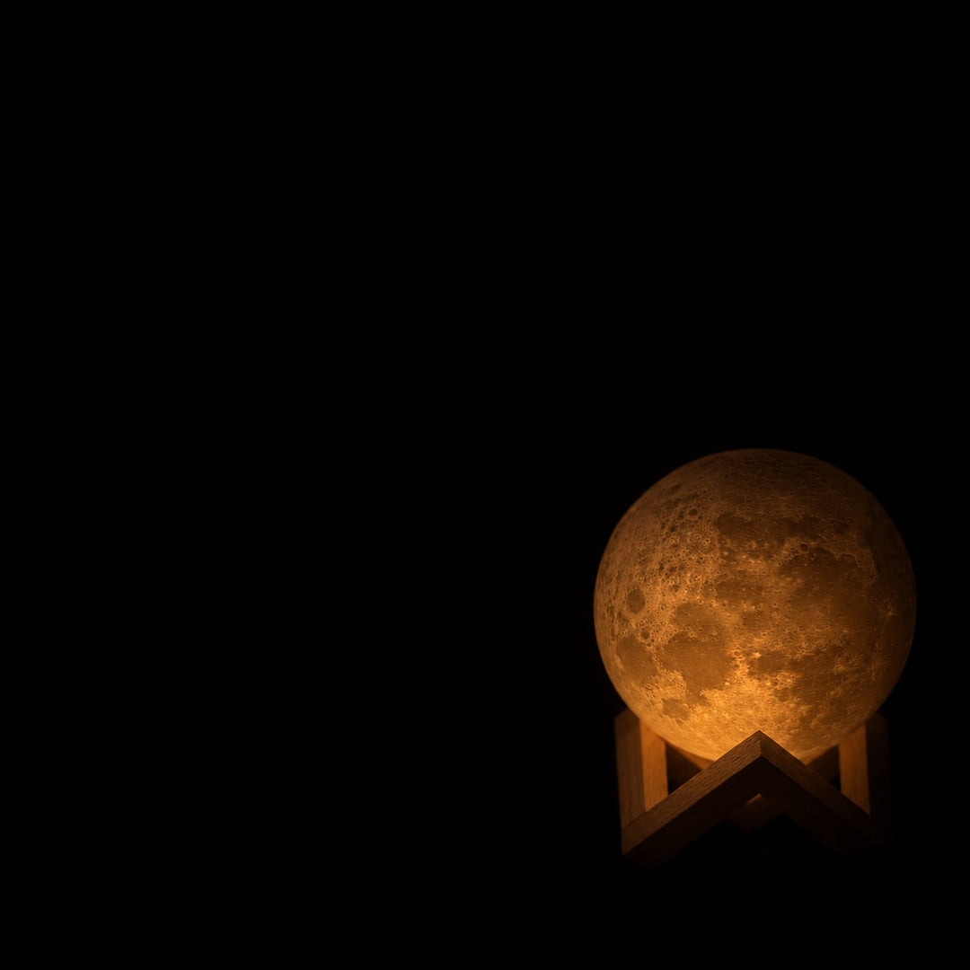 La Petite Lune presque éteinte dans le noir, sur son support en bois