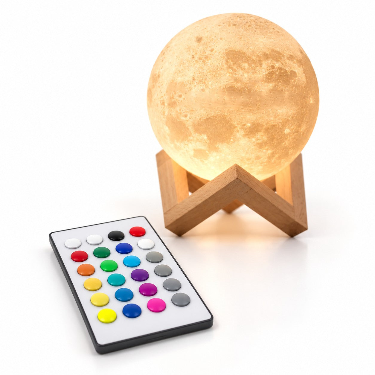 La télécommande de la Petite Lune, devant la lune allumée sur son support en bois